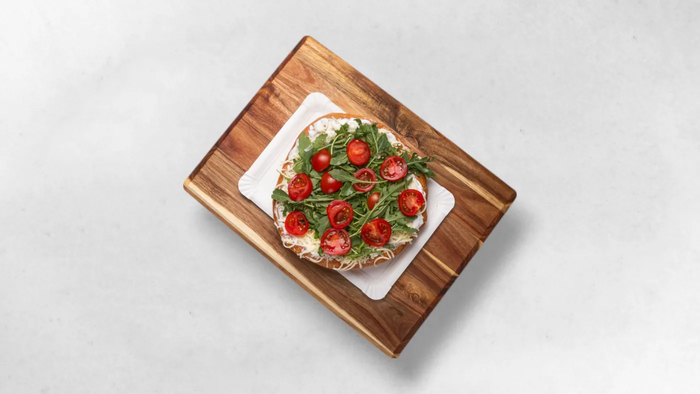 Langos mit Sauerrahm, Käse, Rucola und Tomaten